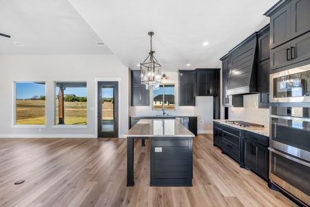 Kitchen with plenty of natural light, a center island, light stone countertops, and tasteful backsplash