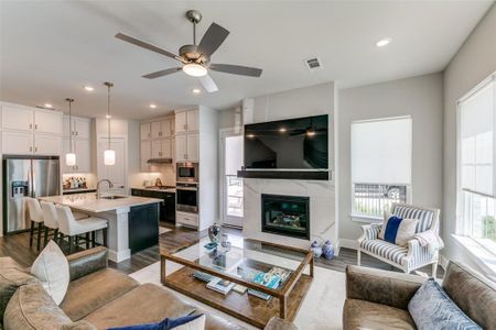 Living room featuring ceiling fan, dark hardwood / wood-style flooring, sink, and a high end fireplace