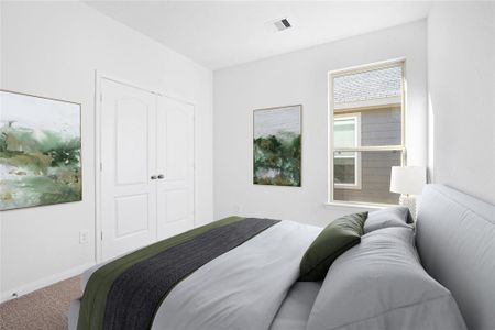 Secondary bedroom features plush carpet, custom paint, ample closet space, and a large window.