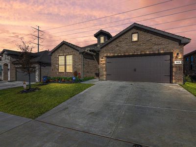 View of front of home with a garage and a yard