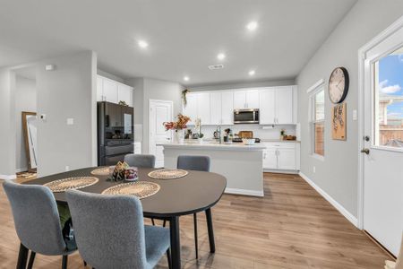 Dining area with sink and light wood-type flooring