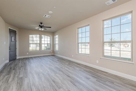 Unfurnished living room with ceiling fan and light hardwood / wood-style flooring