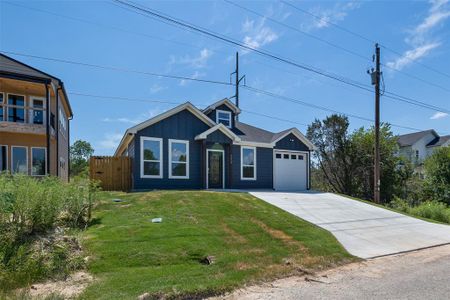 View of front of property featuring a garage and a front yard