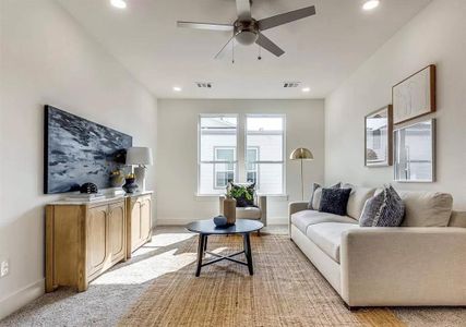 Carpeted living room with ceiling fan