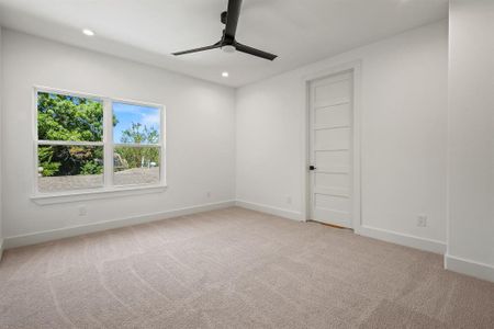 Carpeted spare room with ceiling fan