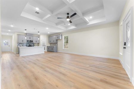 Unfurnished living room with coffered ceiling, beam ceiling, light hardwood / wood-style floors, and ceiling fan