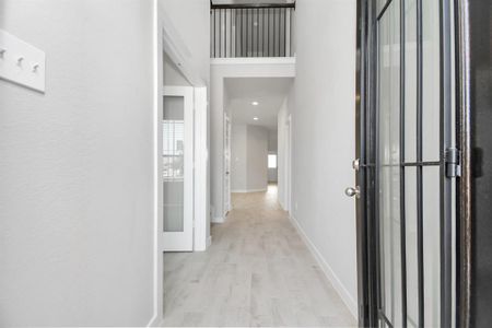 The majestic entryway allures with its high ceilings, embellished with sophisticated wood-look tile flooring and sleek oversized baseboards. Sample photo of completed home with similar floor plan. As-built interior colors and selections may vary.