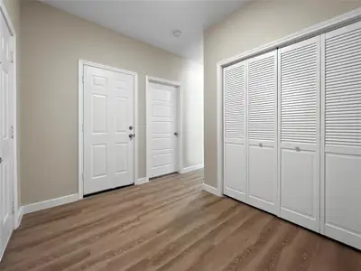 Unfurnished bedroom with wood finished floors and a closet