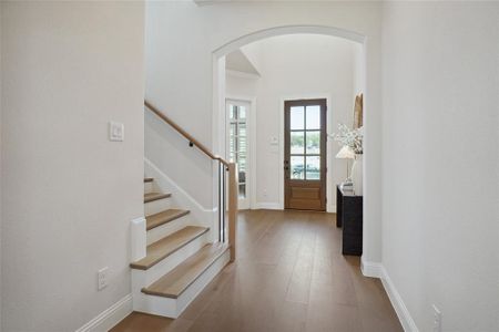 Foyer entrance with hardwood / wood-style flooring and crown molding