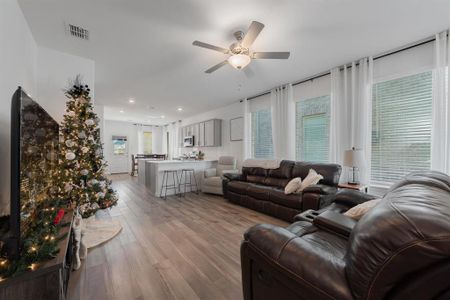 Living room with ceiling fan and light hardwood / wood-style flooring