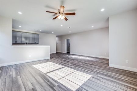 Similar home: Unfurnished living room featuring wood-style flooring and ceiling fan