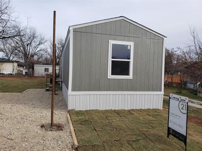 View of property exterior facing street. Carport under construction