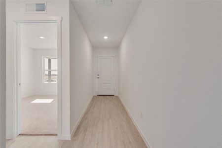 Hallway with light hardwood / wood-style floors