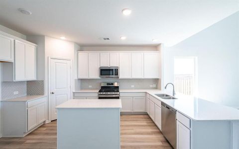 Kitchen with white cabinets, a center island, stainless steel appliances, and sink Kitchen with white cabinets, a center island, stainless steel appliances, and sink