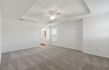 Elegant owner's suite with tray ceiling *real home pictured