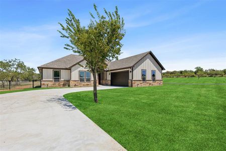 View of front of house featuring a garage and a front lawn