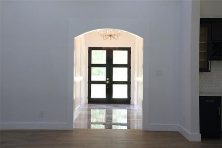 As you walk in to the extended foyer you are greeted by a custom chandelier and marble look tile flooring.