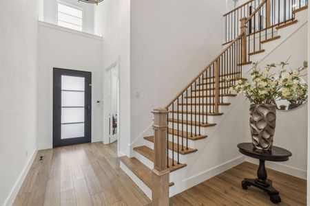 Foyer with hardwood / wood-style flooring and a towering ceiling