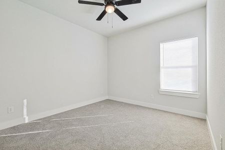 Carpeted empty room featuring ceiling fan