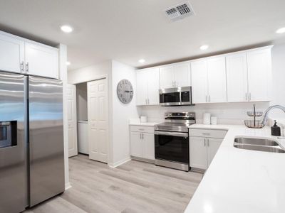 The large kitchen includes ample cabinet and counter space, a pantry, and breakfast bar - Azalea townhome by Highland Homes