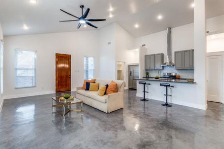 Living room featuring high vaulted ceiling and ceiling fan