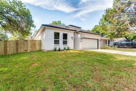 View of front of property featuring a garage and a front yard