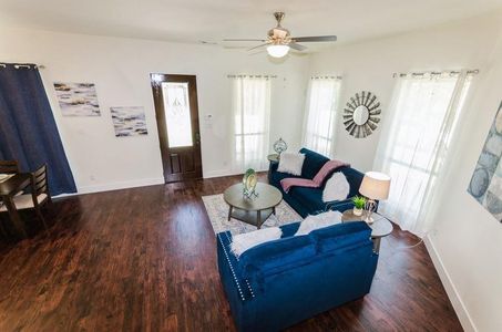 Living room featuring ceiling fan and dark hardwood / wood-style floors