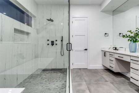 Bathroom featuring tile patterned flooring, vanity, and a shower with shower door