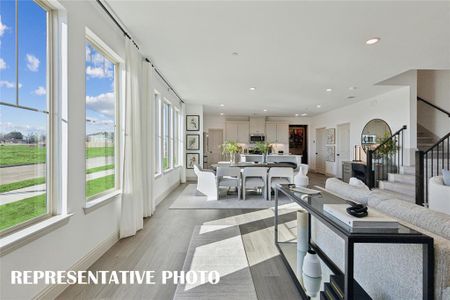 Featuring walls of windows throughout the main floor, this beautiful home is filled with natural light.  REPRESENTATIVE PHOTO