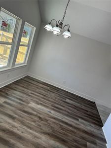 Dinning room featuring hardwood / wood-style floors, a towering ceiling, and a chandelier