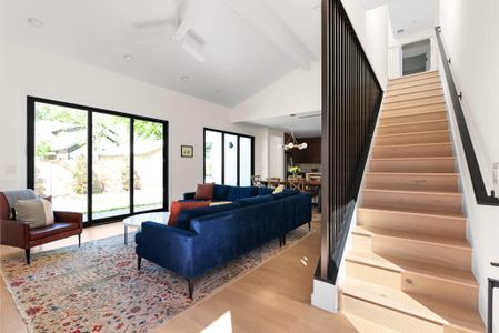 Custom metal staircase railings and triple sliding glass doors leading to large backyard area.