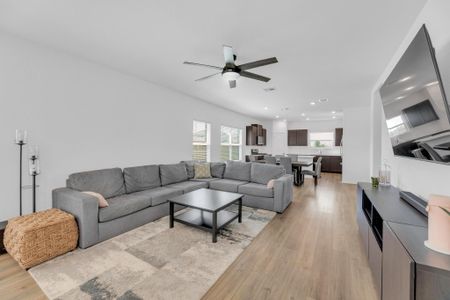 Living area with light wood-type flooring, ceiling fan, visible vents, and recessed lighting Living area with light wood-type flooring, ceiling fan, visible vents, and recessed lighting