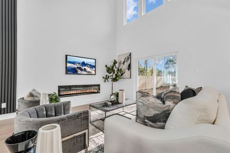 Living room featuring a towering ceiling and hardwood / wood-style flooring