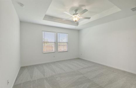 Elegant owner's suite with tray ceiling *real home pictured