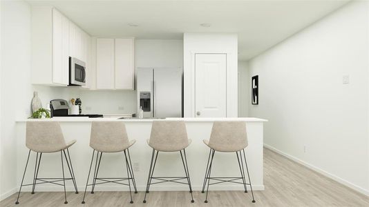 Kitchen featuring stove, a breakfast bar, white refrigerator with ice dispenser, white cabinets, and light hardwood / wood-style floors