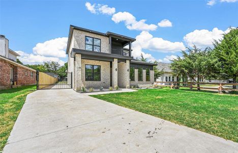 View of front of house featuring a balcony and a front yard