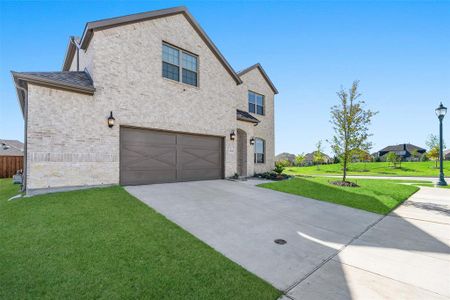 View of front facade featuring a front yard and a garage