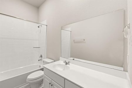 The secondary bath features tile flooring, white cabinetry and light countertops and a shower/tub combo. Perfect for accommodating any visiting family and friends.