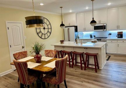 Dining area featuring crown molding, sink, and light hardwood / wood-style flooring