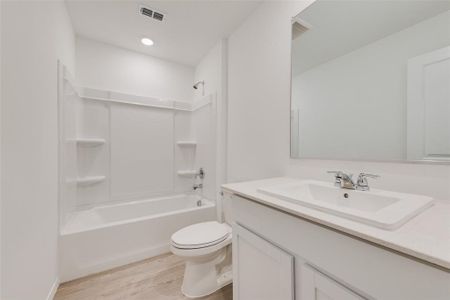 Full bathroom with shower / bathtub combination, wood-type flooring, toilet, and vanity