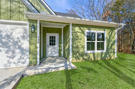 Doorway to property featuring a garage and a yard