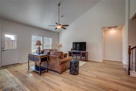 Living room featuring ceiling fan, light hardwood / wood-style floors, and high vaulted ceiling