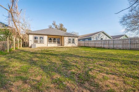 Back of house with cooling unit, a fenced backyard, and a lawn