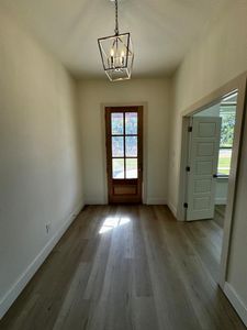 Doorway to outside featuring hardwood / wood-style floors and a chandelier