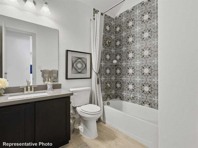 Full bathroom featuring toilet, vanity, and shower / bathtub combination with curtain