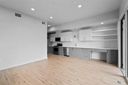 Kitchen featuring stainless steel appliances, tasteful backsplash, visible vents, and light countertops