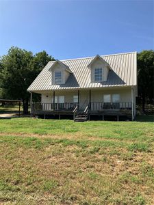 Rear view of house with a yard and a deck