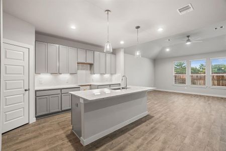 Dream kitchen that exceeds expectations! This generously spacious layout boasts a massive granite island, high ceilings, soft-close cabinets, granite countertops, stainless steel appliances, a sleek tile backsplash, and recessed lighting. The open concept seamlessly connects this culinary haven to the expansive family room, creating the perfect hub for gatherings. Sample photo of completed home with similar floor plan. As-built interior colors and selections may vary.