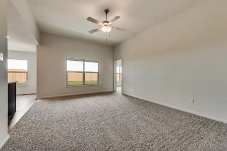 Empty room with ceiling fan, a healthy amount of sunlight, and light colored carpet