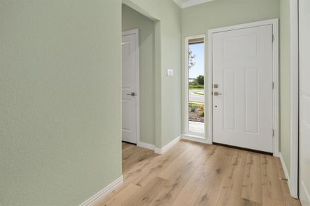 Entrance foyer with crown molding and light hardwood / wood-style flooring